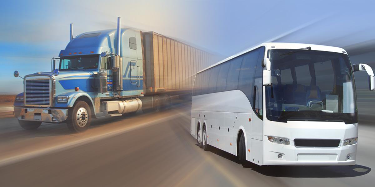 A motor coach and tractor trailer on the highway.